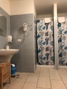 格拉多的住宿－大西洋公寓酒店，浴室配有淋浴帘和盥洗盆。