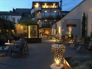 a building with a vase on a patio at night at Le Florentin in Florenville