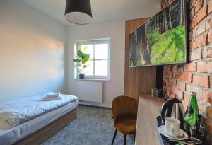 sypialnia z łóżkiem i ścianą z cegły w obiekcie ApartHOTEL Gostyń w mieście Gostyń
