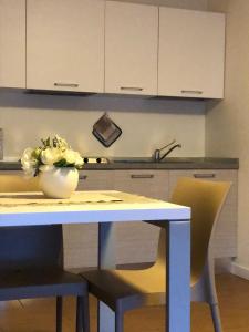 a kitchen with a table with a vase of flowers on it at Apart Hotel Atlantic in Grado