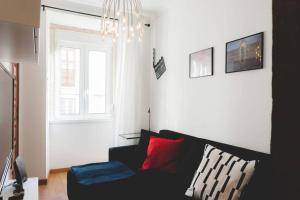 uma sala de estar com um sofá preto e uma janela em Welcome to Alcântara Apartment em Lisboa