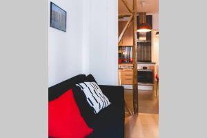 a living room with a red and white pillow on a couch at Welcome to Alcântara Apartment in Lisbon