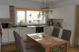 a kitchen with a wooden table and a table and chairs at Top 2 Zi-Wohnung, 350 m zum See in Friedrichshafen