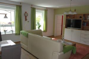 a living room with a white couch and a tv at Top 2 Zi-Wohnung, 350 m zum See in Friedrichshafen