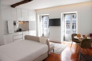 um quarto com uma cama e uma cozinha com uma mesa em GuimaraesIN em Guimarães
