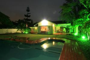 a house with a pool in the yard at night at La Loggia on Portland in Durban