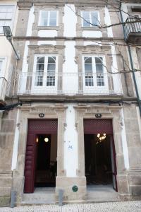 a white building with two doors and windows at GuimaraesIN in Guimarães