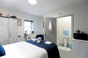 a bedroom with a bed and a bathroom with a sink at Contractor friendly from 'TOBS Norwich' in Norwich