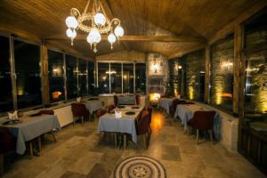 a restaurant with tables and chairs and a chandelier at Antique House Cappadocia in Nevsehir