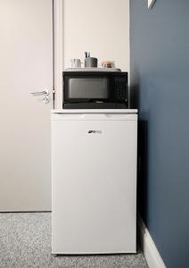 a microwave sitting on top of a white refrigerator at Contractor friendly from 'TOBS Norwich' in Norwich