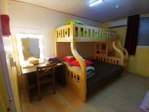 - une chambre avec des lits superposés, un bureau et des lits superposés dans l'établissement Daejeon Guesthouse Sky Garden, à Daejeon
