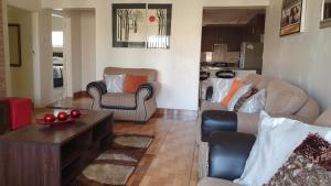 a living room with two chairs and a coffee table at Grey Oak Holiday House in Bulawayo