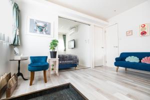 ein Wohnzimmer mit einem blauen Sofa und einem Bett in der Unterkunft belle lune hotel hakata Suite Room 3 in Fukuoka