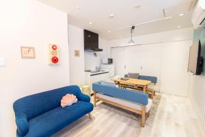 a living room with two blue couches and a table at belle lune hotel hakata Suite Room 3 in Fukuoka +44 photos
