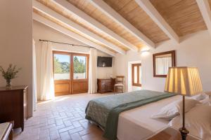 a bedroom with a bed and a desk and a window at Agroturisme Gossalba in Sant Joan