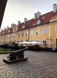 um grande edifício com um canhão à frente dele em 2 level apartments in Old Town em Riga