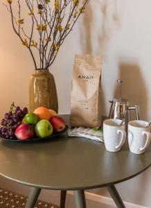 a table with a plate of fruit and two cups at Fiddle + Bow Hotel in Doolin