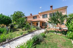 une maison avec un jardin en face dans l'établissement Beautiful villa Loreta with private pool near Pula and Rovinj, à Čabrunići