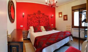 um quarto vermelho com uma cama e uma parede vermelha em Legado De Zabala, Casa Rural em Laguardia