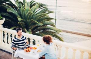 a man and a woman sitting at a table eating food at Spring Arona Gran Hotel - Adults Only in Los Cristianos