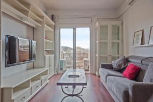 - un salon avec un canapé et une télévision dans l'établissement Alcam Augusta, à Barcelone