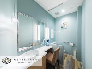 a bathroom with a sink and a mirror at Astil Hotel Juso Precious in Osaka