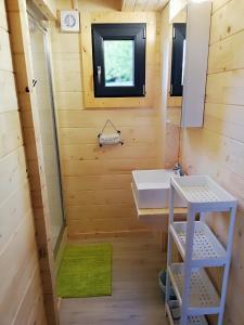 La petite salle de bains est pourvue d'un lavabo et d'un miroir. dans l'établissement Les Chalets de Grazimis, à Condom