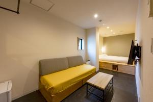 uma sala de estar com um sofá e uma cama em plat hostel keikyu minowa forest em Tóquio