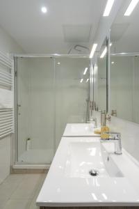 a white bathroom with a sink and a shower at APG Palau Salieti 2 in Girona