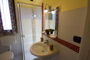 a bathroom with a sink and a toilet and a mirror at Hotel Merlino in Avola