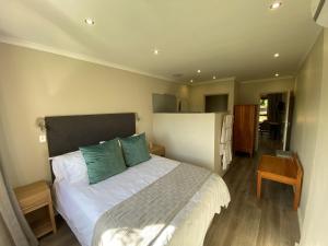 een slaapkamer met een groot wit bed met groene kussens bij Viettz Suite Annex in Stellenbosch