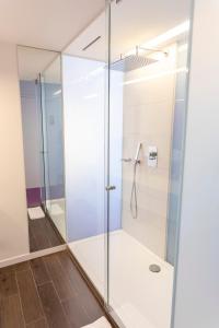 a shower with glass doors in a bathroom at Eburon Hotel in Tongeren