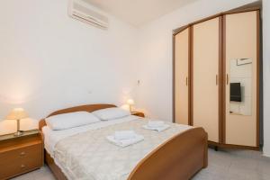a bedroom with a large bed with two towels on it at Apartments Maestral in Orebić +103 photos