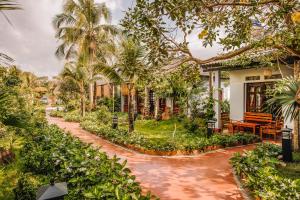 una casa con palmeras y una pasarela en Palm Hills Resort, en Phu Quoc