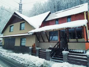 a house with snow on the roof at Casa Savianu Cavnic in Cavnic