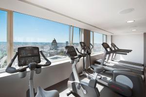 een fitnessruimte met cardio-apparatuur in een kamer met een raam bij The Hotel Brussels in Brussel