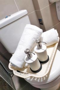 a bathroom with a white toilet with towels on it at Beautiful Relaxing Home in SkyArena Ascenda (3-6pax) in Kuala Lumpur