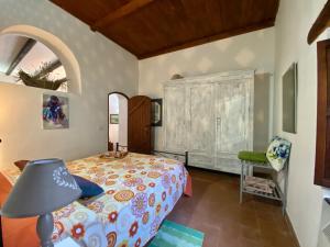 een slaapkamer met een bed, een lamp en een stoel bij Holidaycasa Martina - Nel cuore del Centro Storico in Sperlonga