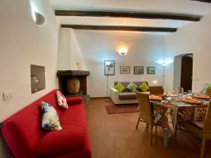 a living room with a red couch and a table at Holidaycasa Martina - Nel cuore del Centro Storico in Sperlonga