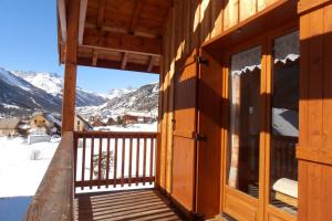 a view from the porch of a cabin with snow covered mountains at L'Echaillon - Ancolie in Névache