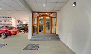 wejście do budynku z drewnianymi drzwiami w obiekcie Treebo Trend Petals Suites Ernakulam Town w mieście Koczin