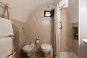 a bathroom with a toilet and a sink and a shower at White House Flats & Studios in Ostuni
