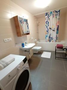 a bathroom with a washing machine and a sink at Prima Family Apartments in Prague