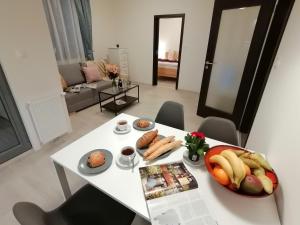 a white table with a bowl of fruit and food on it at Prima Family Apartments in Prague