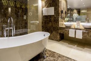 a bath tub sitting next to a sink in a bathroom at Wellington Hotel & Spa Madrid in Madrid