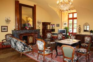 salon z kominkiem, stołem i krzesłami w obiekcie Chateau de Creissels w mieście Creissels