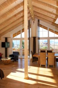 een woonkamer met houten plafonds en een tafel en stoelen bij Landhaus Kössel in Füssen