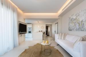 a living room with a white couch and a table at Onira Suite Dreams in Hersonissos
