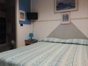 a bedroom with a bed with a blue and white comforter at Hotel Niagara in Caselle Torinese