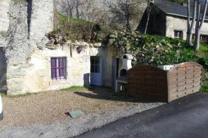 ein altes Steinhaus mit lila Tür in der Unterkunft Les Hauts de Nazelles in Nazelles